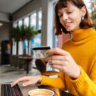 Happy young woman shopping online with credit card